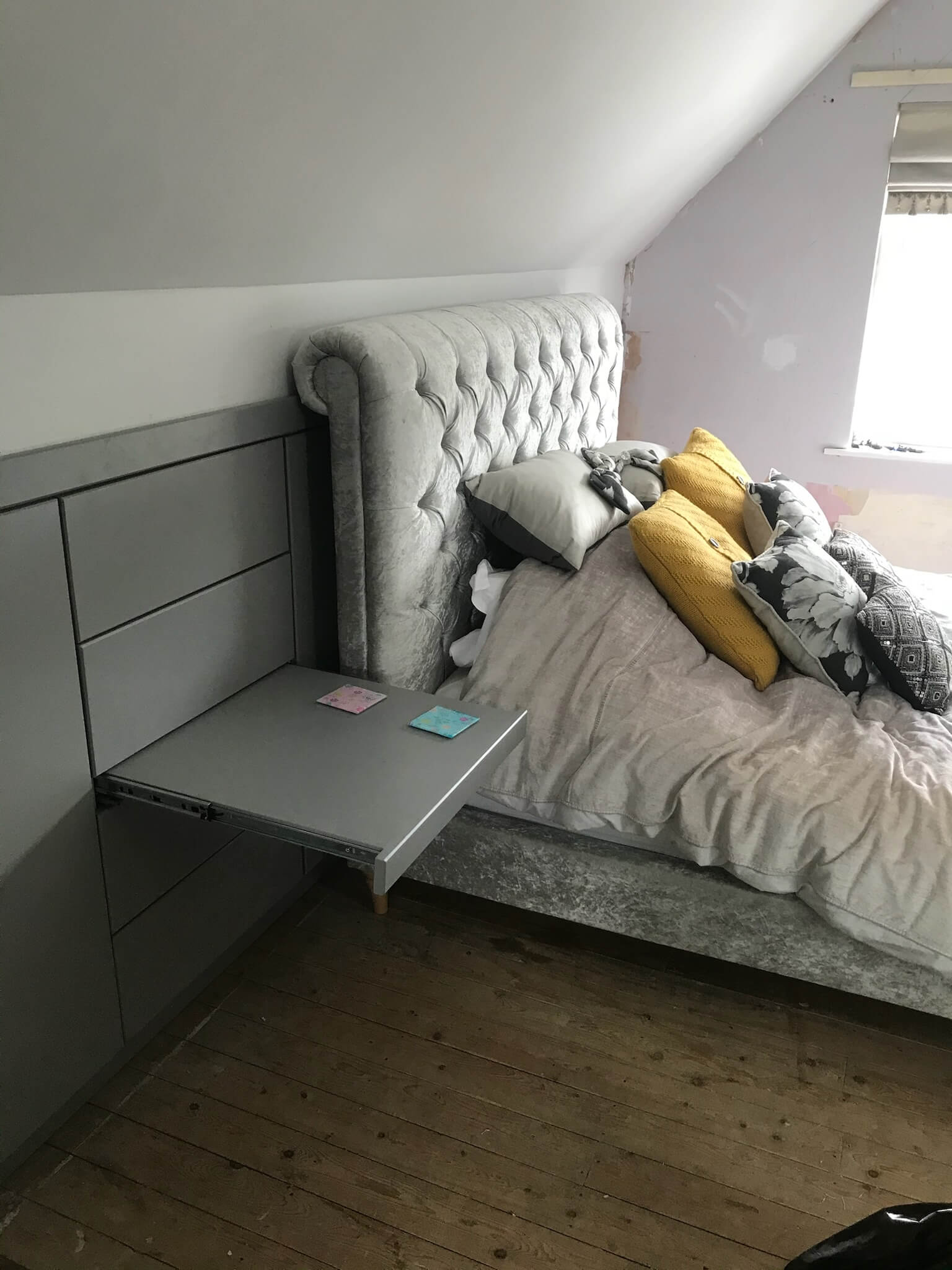 Loft bedroom bed positioned beside a built-in push-to-open bedside shelf, showing how it works at bed height, by JAX Bespoke