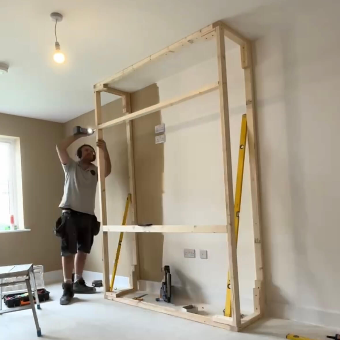 Jack Westmoreland installing a bespoke timber media wall frame in a customer's home in Horbury, Wakefield