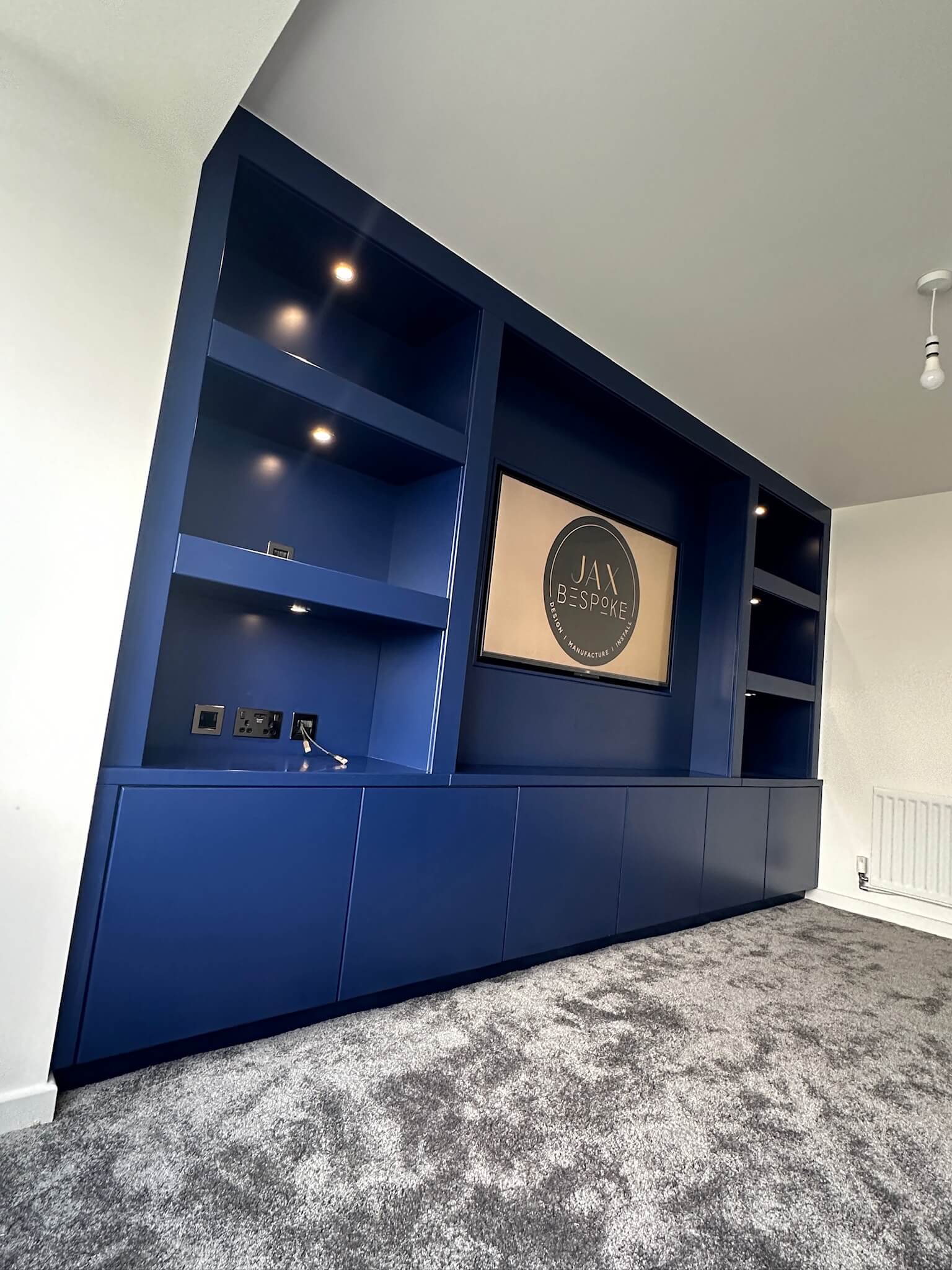 Bespoke media wall with integrated TV unit, storage and shelving designed for a Wakefield living room, by JAX Bespoke