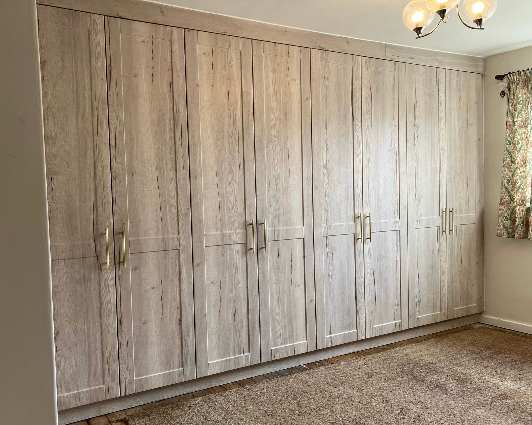 Floor-to-ceiling bespoke fitted wardrobe with hinged doors, painted finish and full-height storage, designed and installed by JAX Bespoke