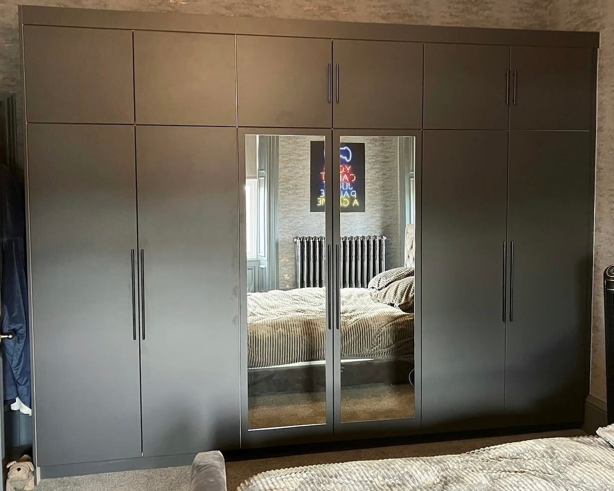 Sprayed stone wardrobe with long matt black handles and mirrored doors by JAX Bespoke — Ilkley, Yorkshire
