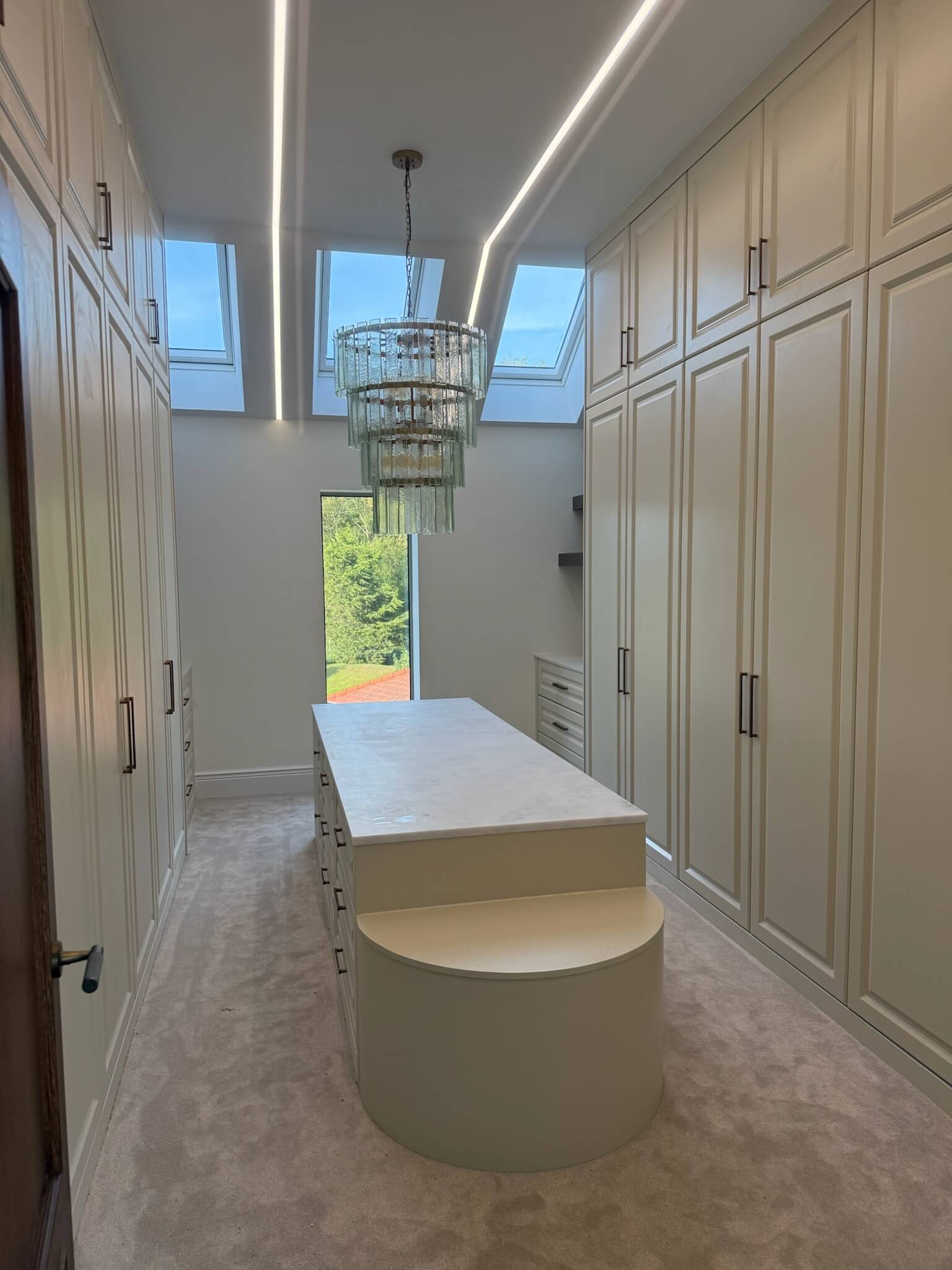 Bespoke walk-in dressing room with floor-to-ceiling fitted wardrobes and island unit, designed and built by JAX Bespoke Yorkshire