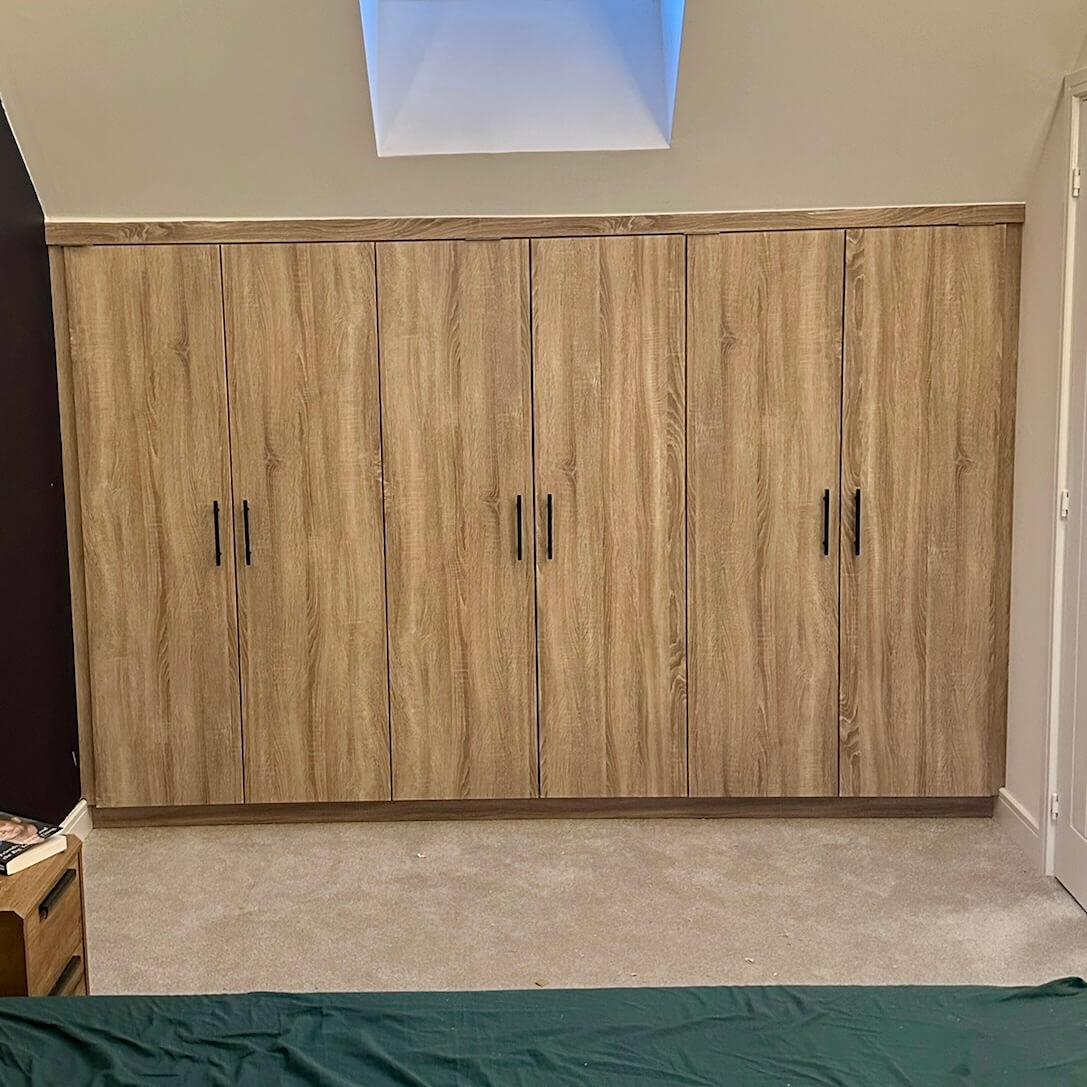 Floor-to-ceiling bespoke fitted wardrobe with hinged doors and organised interior, by JAX Bespoke Leeds