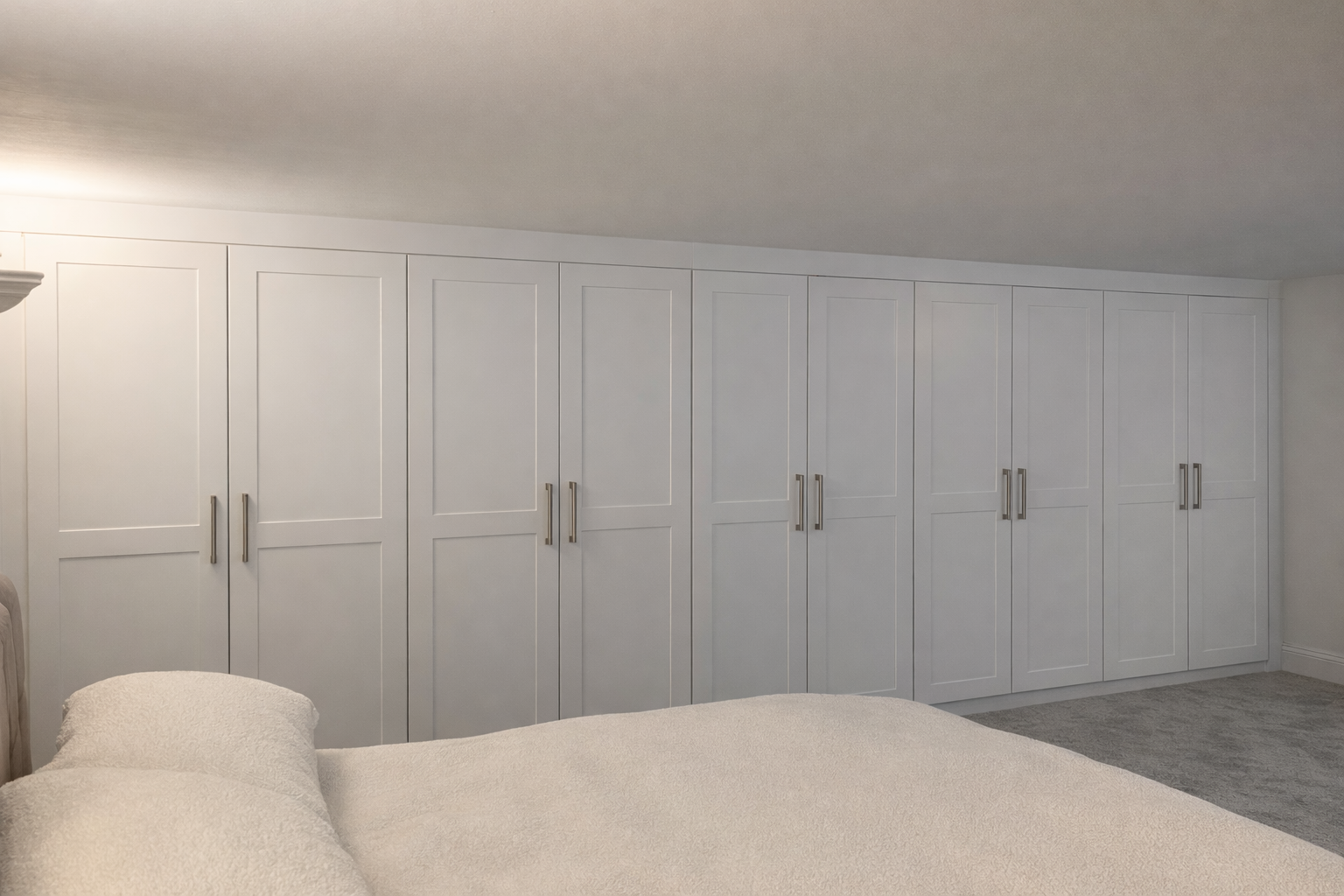 wall to wall fitted wardrobes across bedroom maximising storage space UK