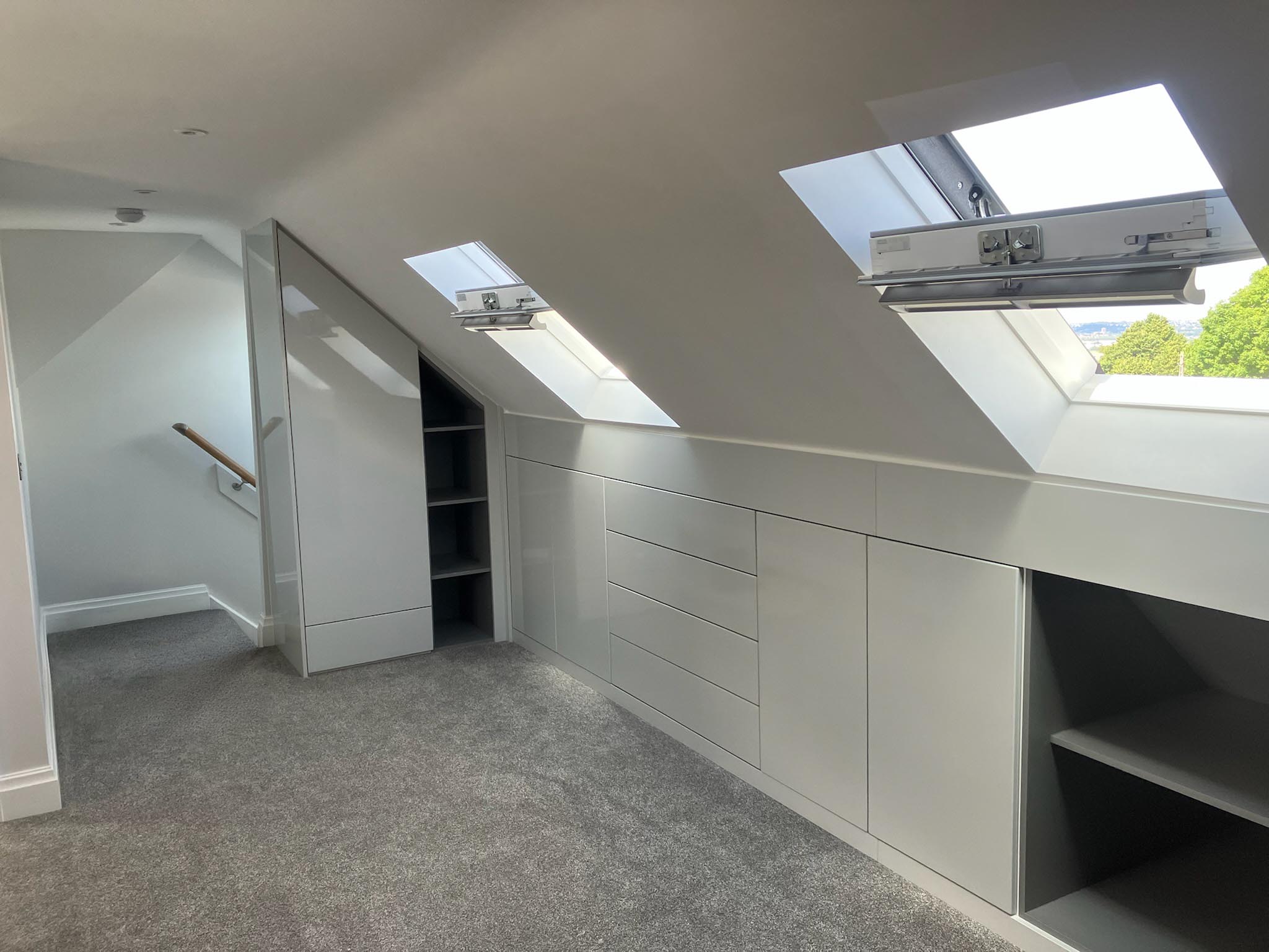 bespoke fitted loft wardrobes with drawers under sloped ceiling skylight bedroom storage solution UK