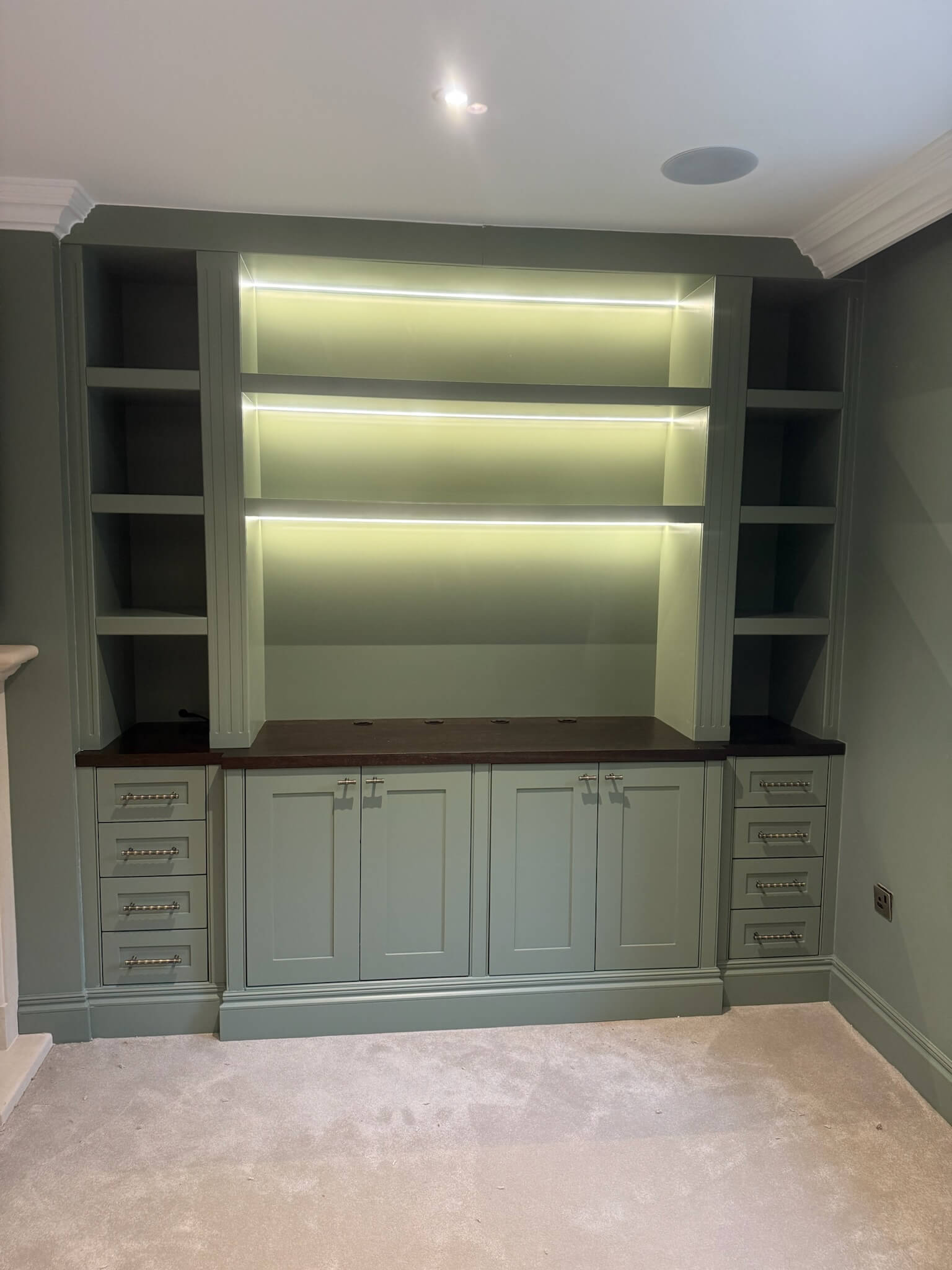 Custom fitted alcove unit with shelving and cabinetry built precisely into a chimney breast recess, by JAX Bespoke