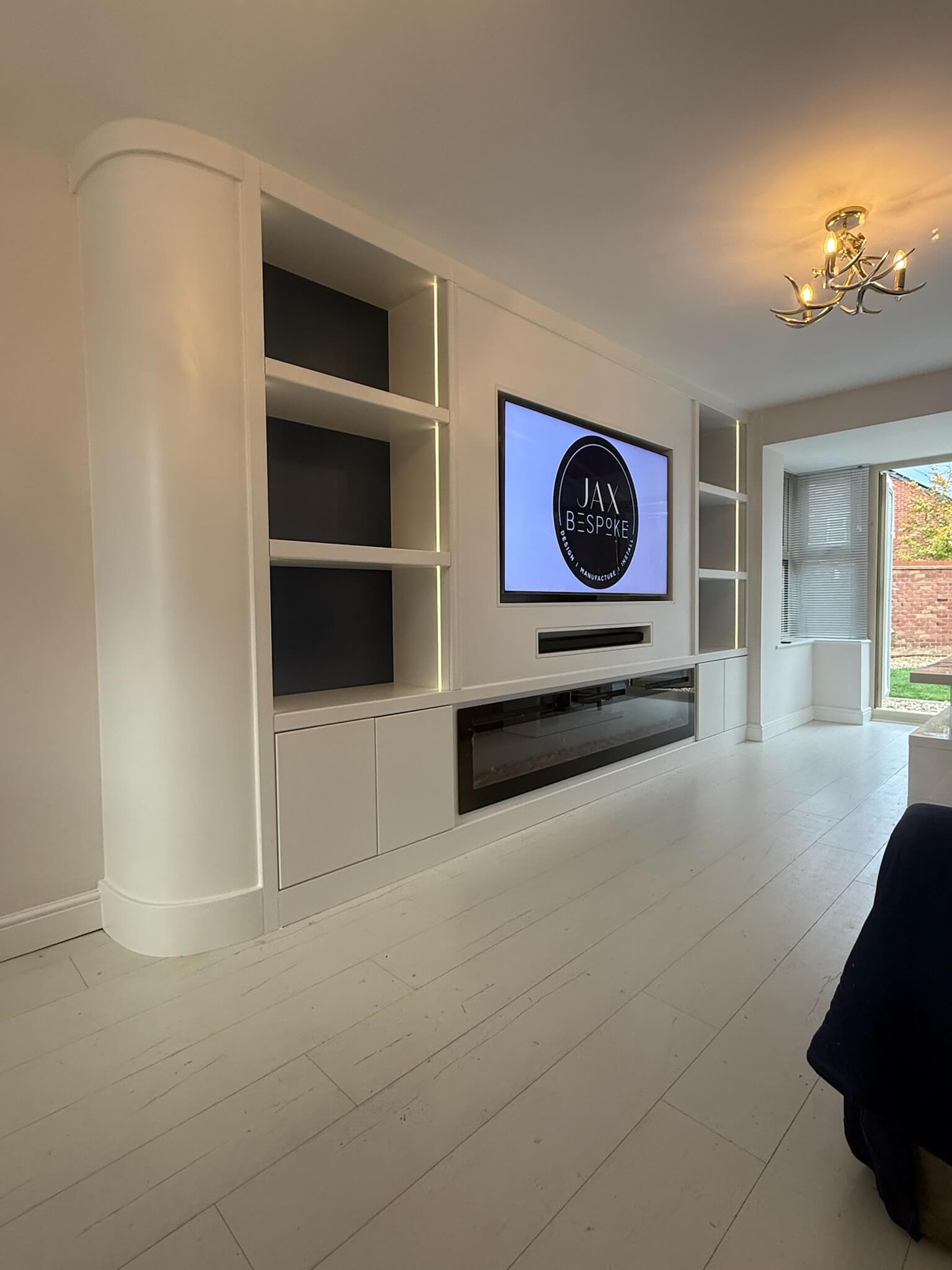Bespoke media wall with curved detail and integrated electric fire, a statement living room installation by JAX Bespoke