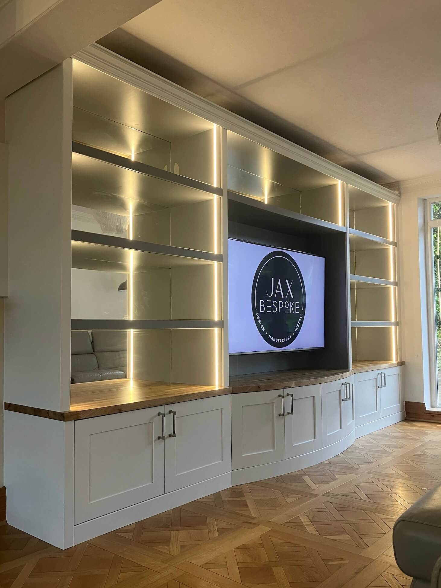 Bespoke curved cabinetry media wall with mirrored back panels, a unique statement piece designed and built by JAX Bespoke Yorkshire