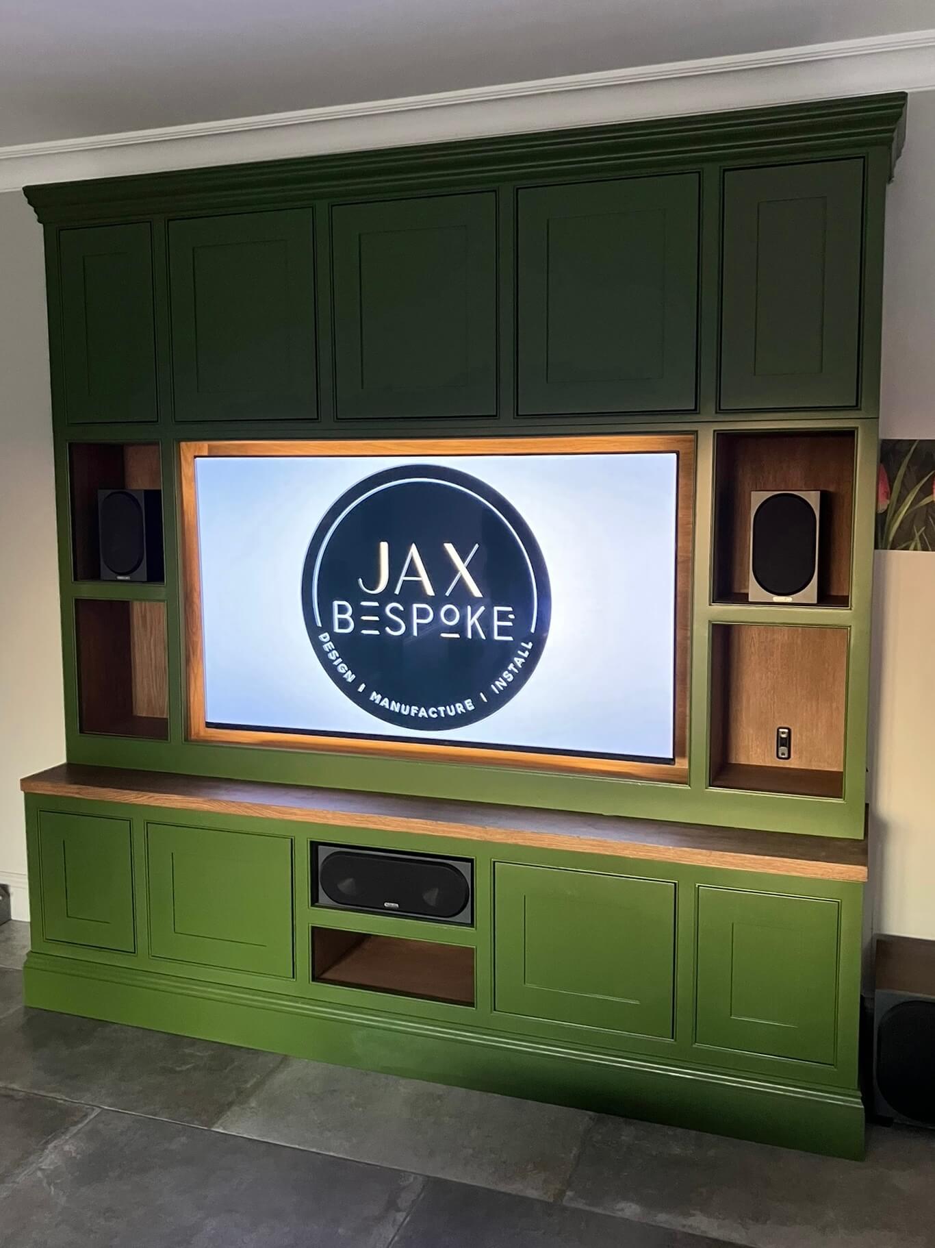 Bespoke green painted cabinetry media wall with integrated TV unit and oak shelving, handcrafted and installed by JAX Bespoke Yorkshire