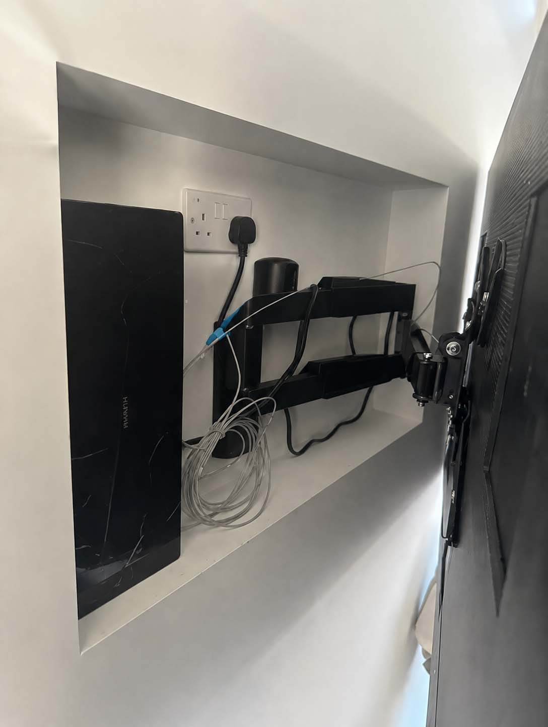 Bespoke media wall cable management detail showing integrated wiring and socket placement, planned and installed by JAX Bespoke Yorkshire