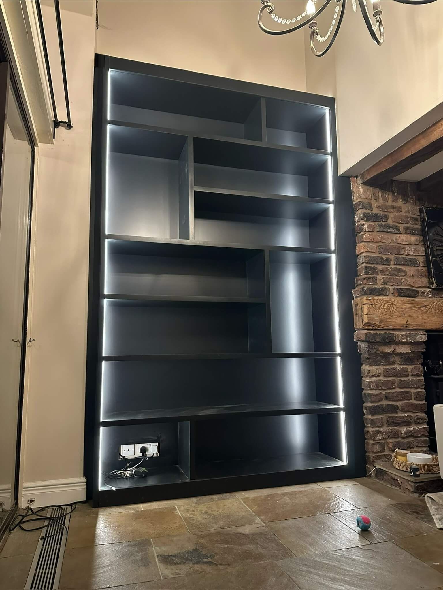 Fitted alcove bookcase with floor-to-ceiling shelving and cabinetry base in a period Yorkshire home, by JAX Bespoke