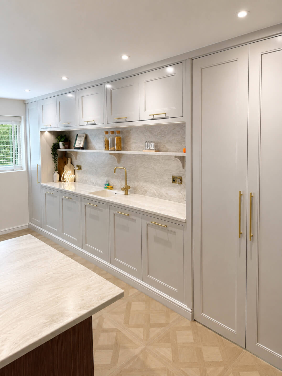 Bespoke kitchen cabinetry run with open shelving, marble-effect splashback and brass hardware, handcrafted by JAX Bespoke
