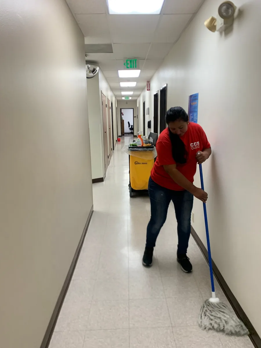 CCS employee mopping commercial facility hallway