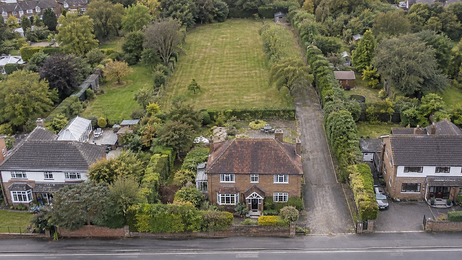 Aerial view of a long rear garden behind a detached house