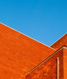 Clean red brick building exterior against a blue sky after cleaning