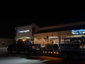 Company truck, trailer and lift working a commercial property after hours