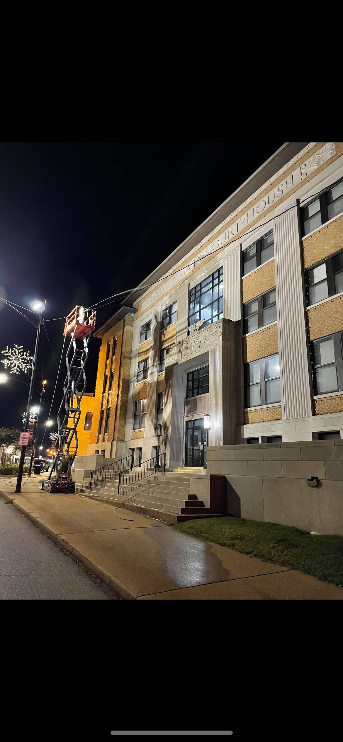 Crew working from a lift on the courthouse facade at night