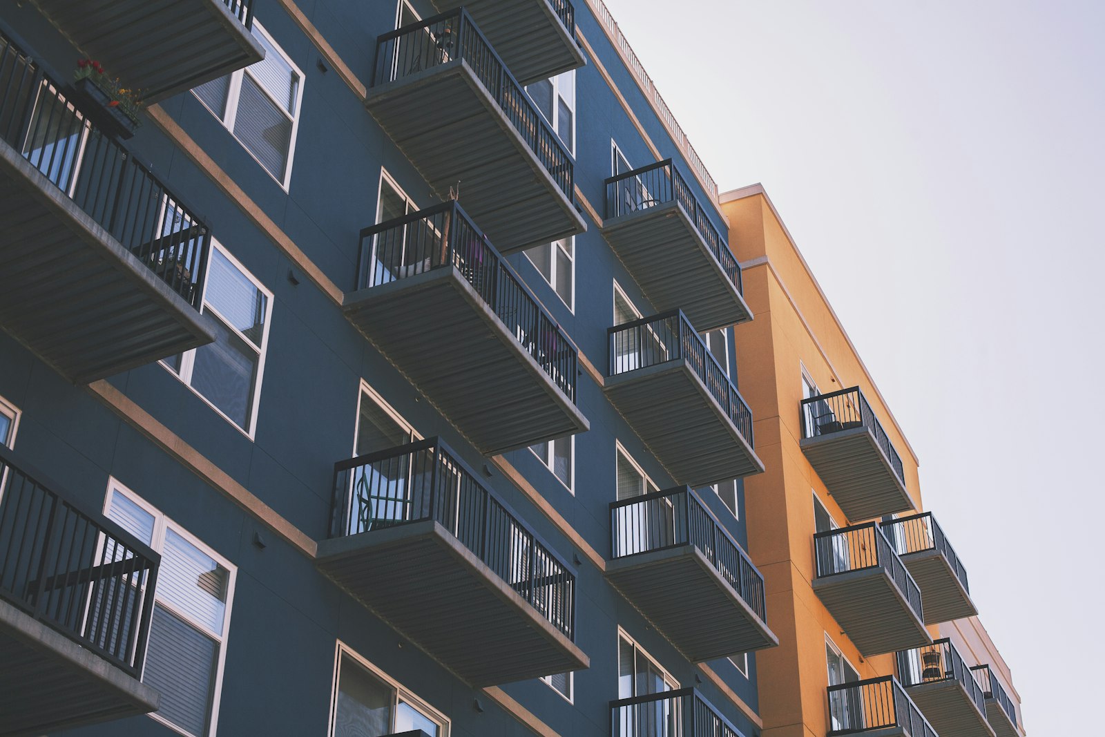 Mid-rise rental building with stacked glass balconies under a clear sky, typical of North York apartment stock