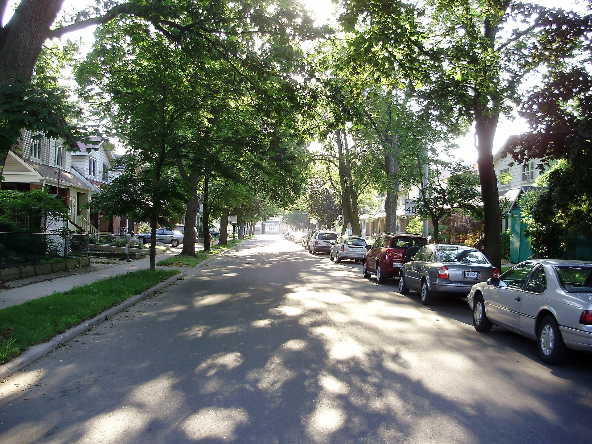 Tree lined residential street with brick houses and parked cars on Milverton Boulevard in Danforth Village, Toronto Tree lined residential street with brick houses and parked cars on Milverton Boulevard in Danforth Village, Toronto