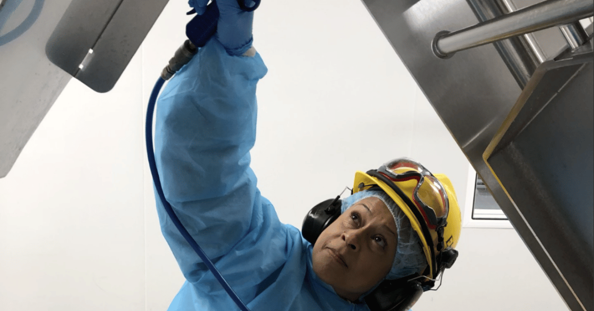 Esther wearing a yellow hard hat at an Elite sanitation site