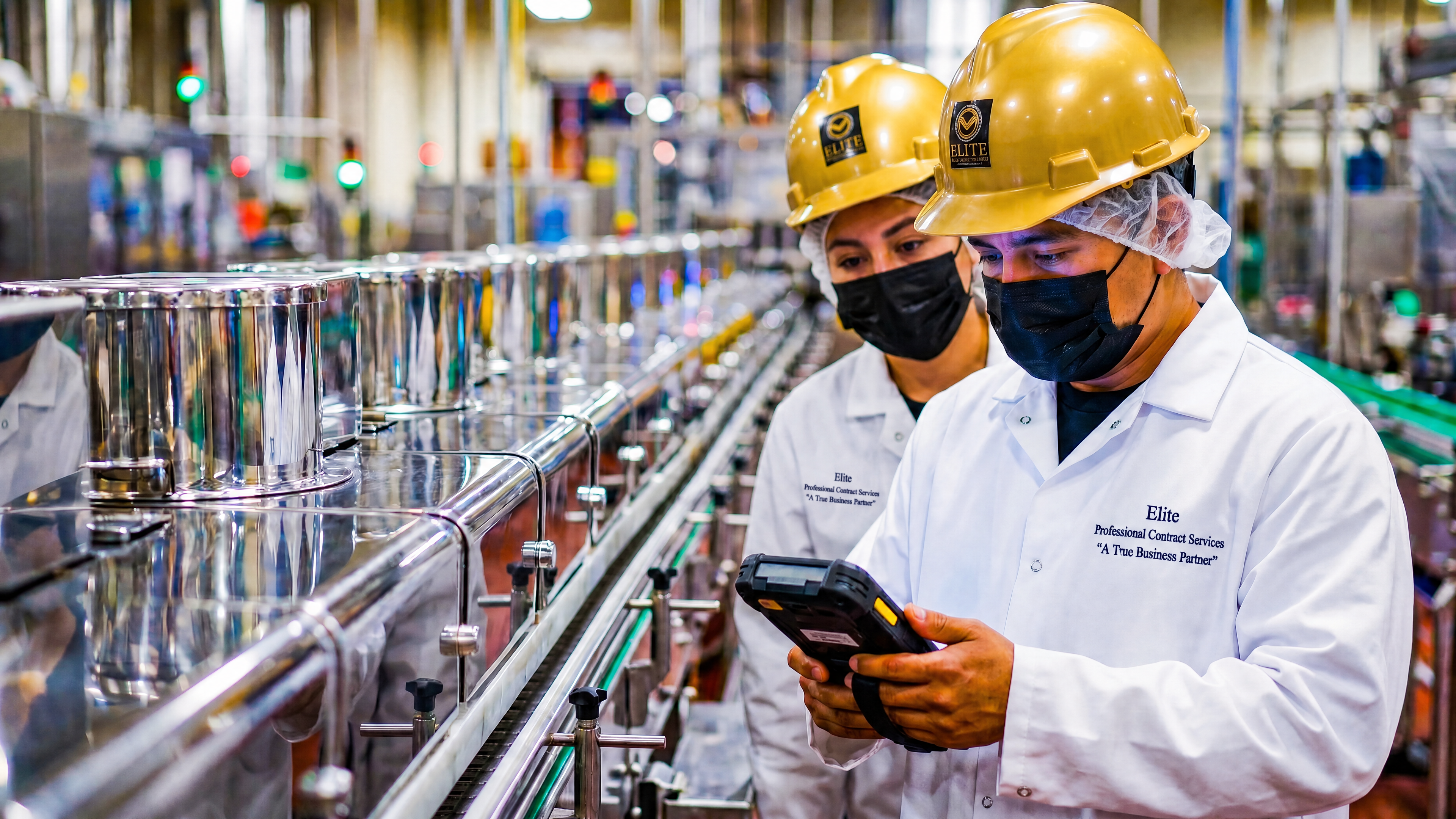 Elite inspectors in hairnets and full PPE conducting compliance review at a food processing facility