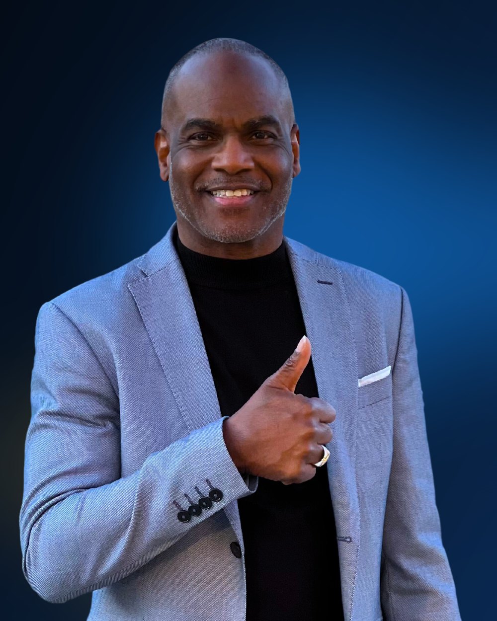 Dwayne Golden in a light blue suit giving a thumbs up