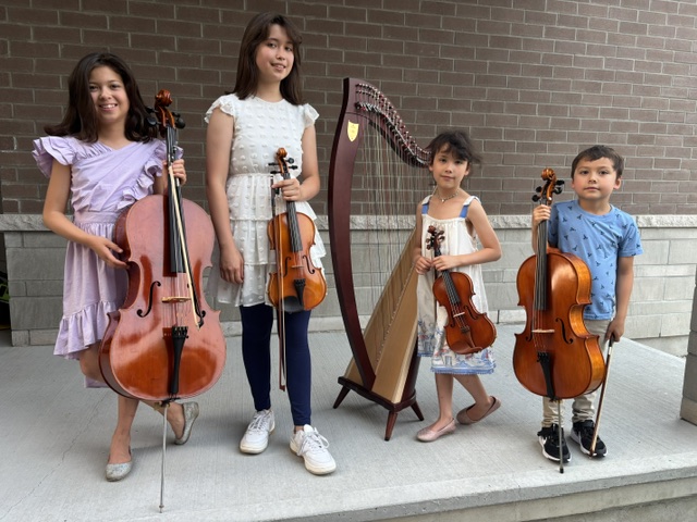 Four young musicians with cello, violin, harp, and cello