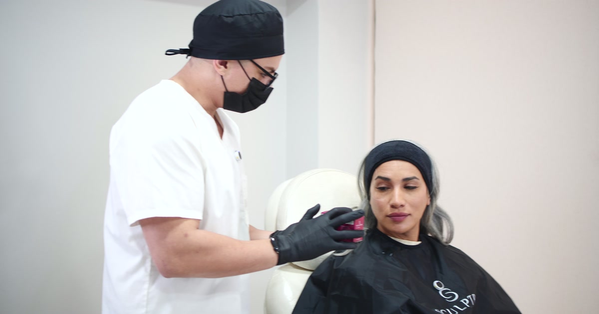 Dr. Criss preparando el material junto a una paciente sentada en el sillón