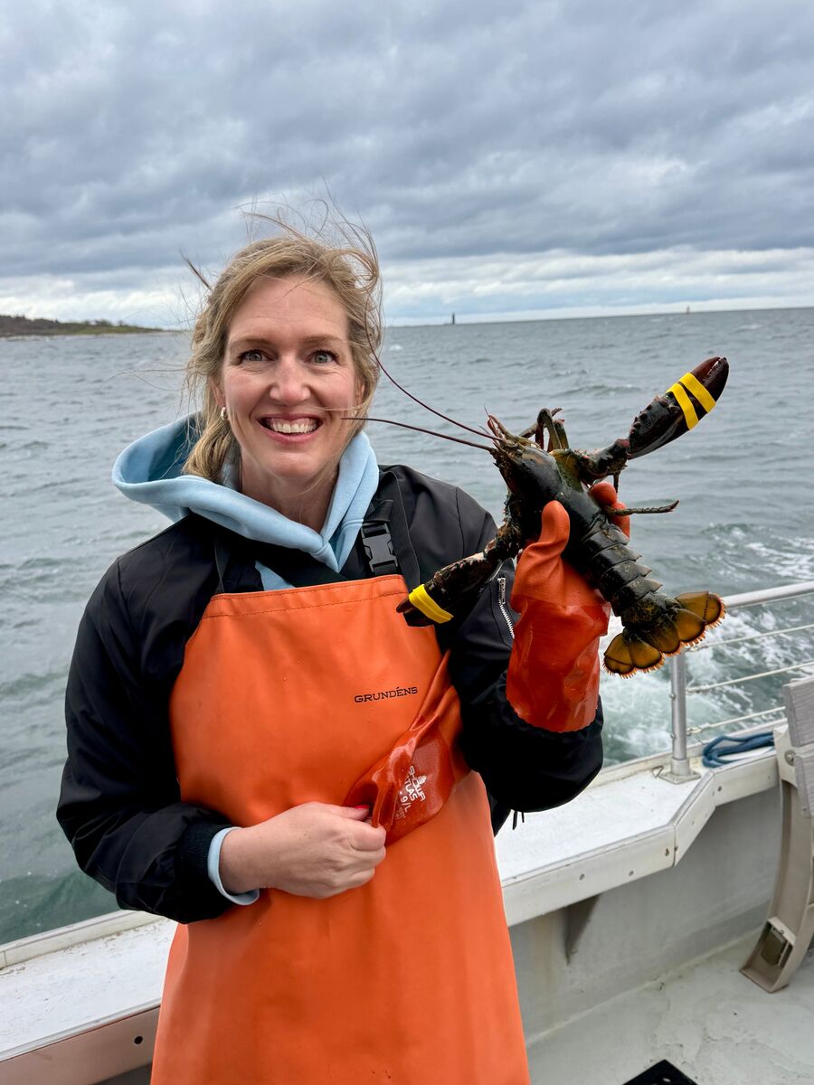 Jody holding a lobster on a boat