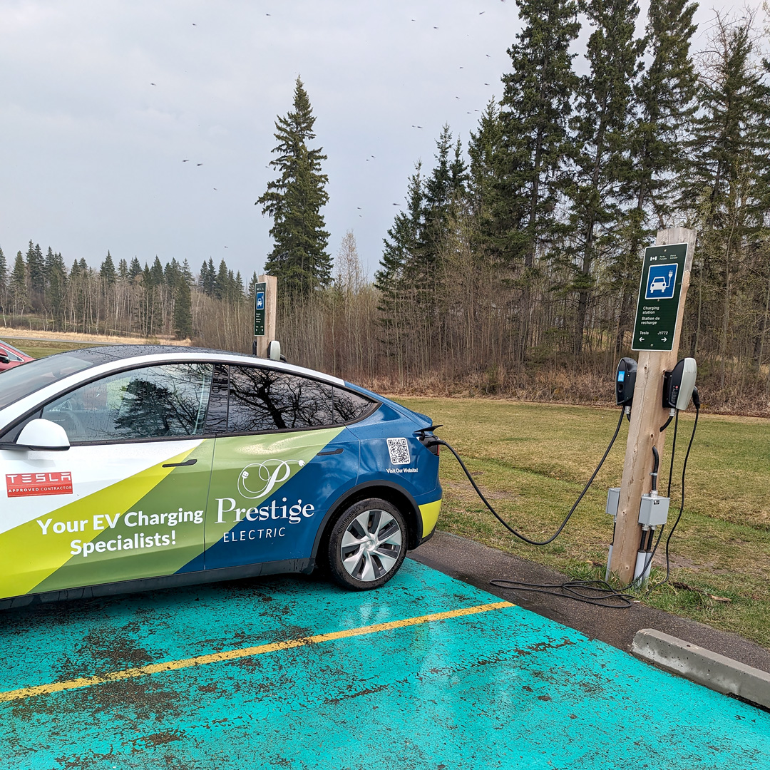 Sleek Tesla electric vehicle connected to a professional Prestige Electric EV charger