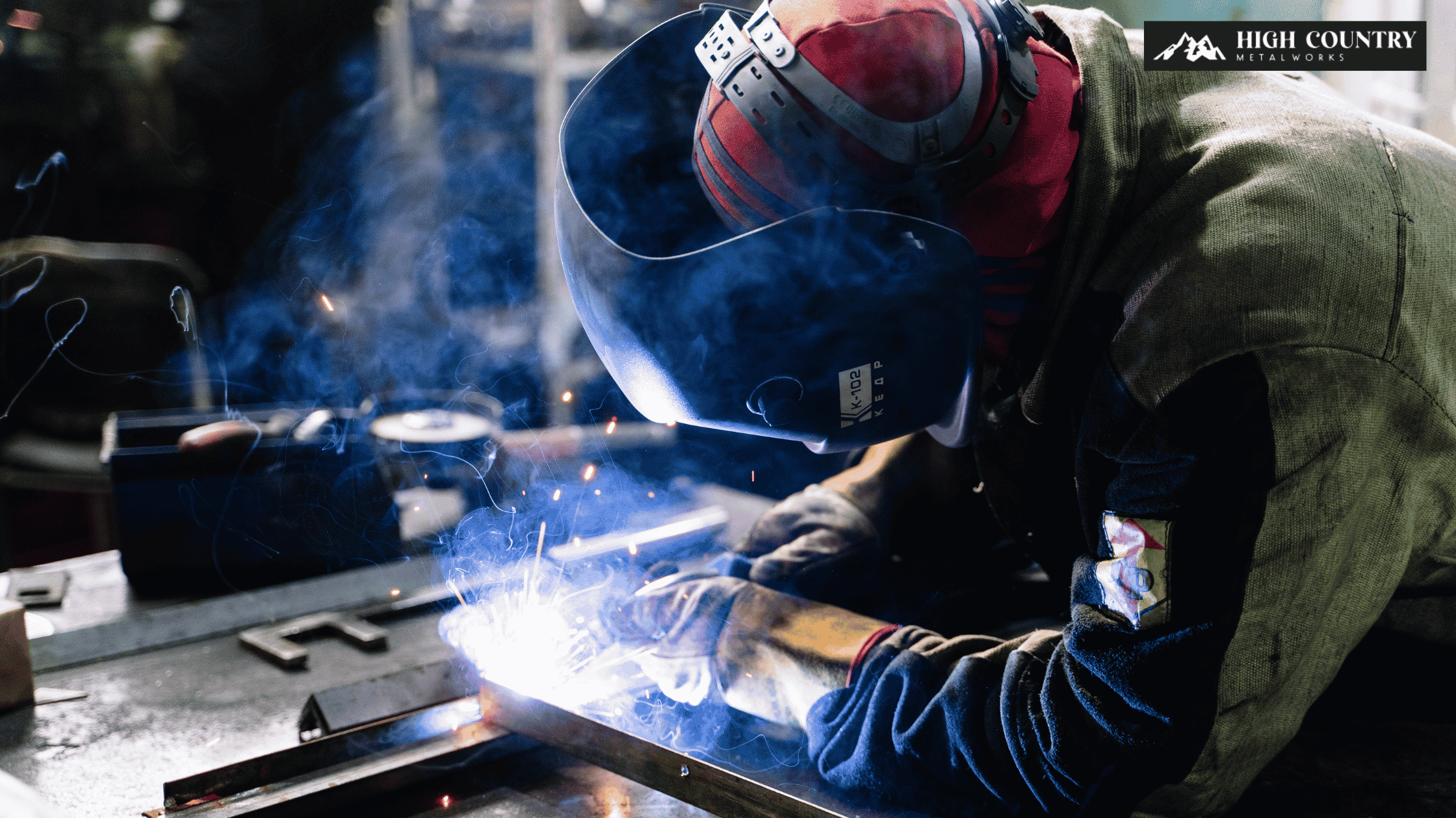Metal fabricator welding a metal fence in metal shop.