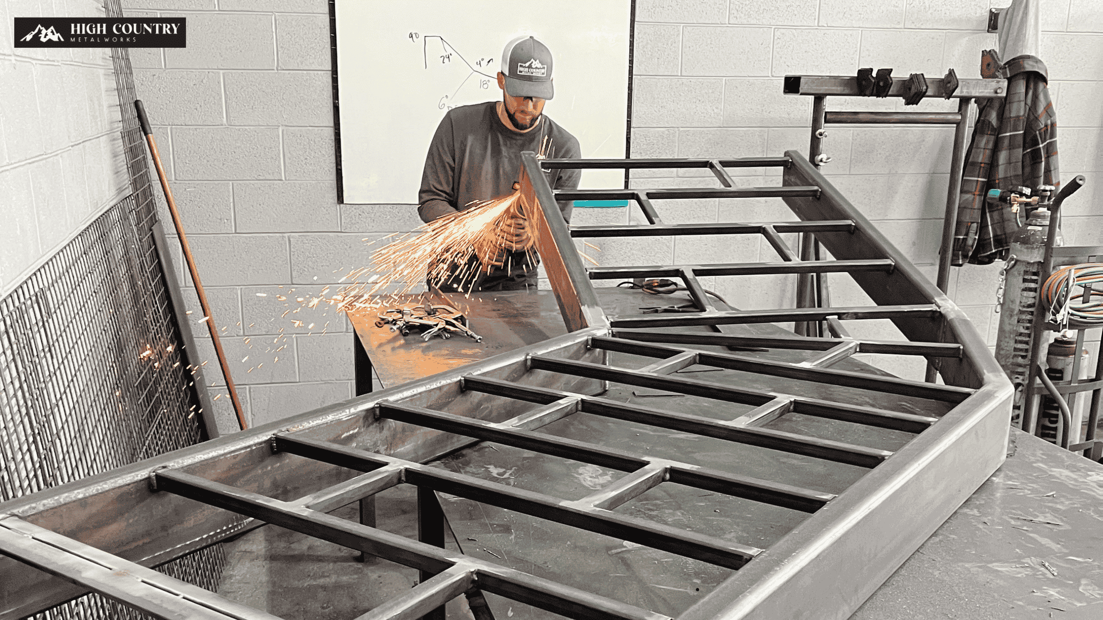 A welding contractor welding a metal frame in a workshop, illustrating the complexities of construction subcontractor timelines.