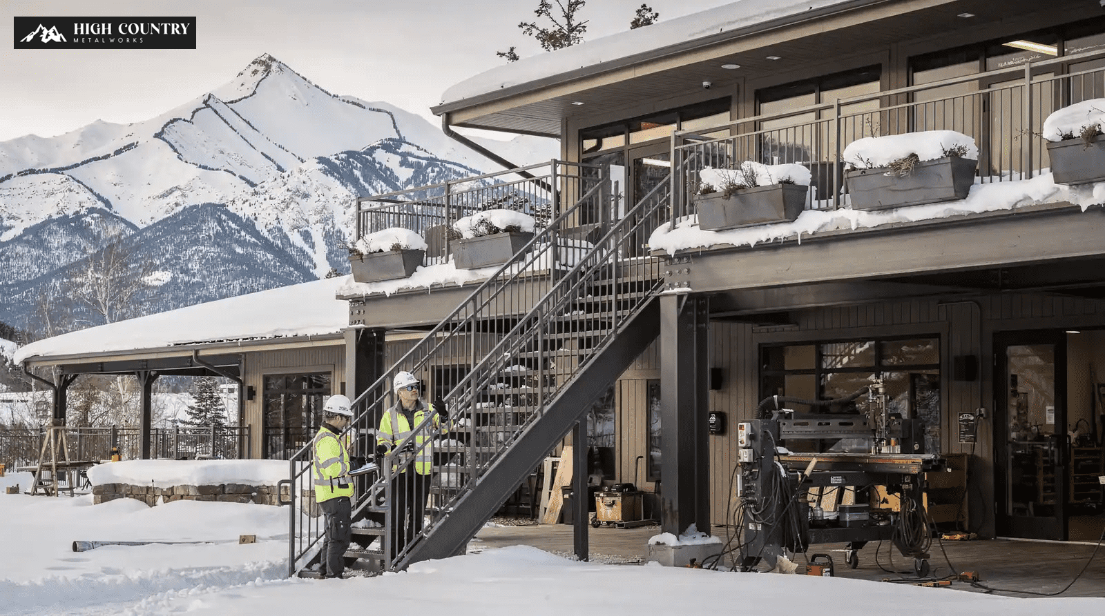 A fabricator and engineer stands on outdoor stairs, inspecting the building in preparation for Utah's first snow load. A fabricator and engineer stands on outdoor stairs, inspecting the building in preparation for Utah's first snow load.