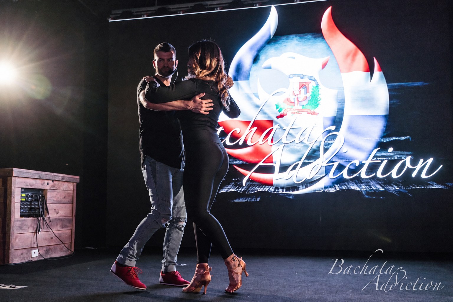 Brandon and Skye demonstrating Bachata in front of the Bachata Addiction backdrop