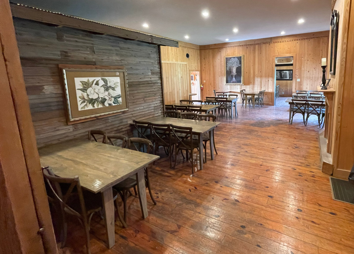 The dining room at Haifa's Magnolia Grill & Pub — farm tables and heart-pine floors