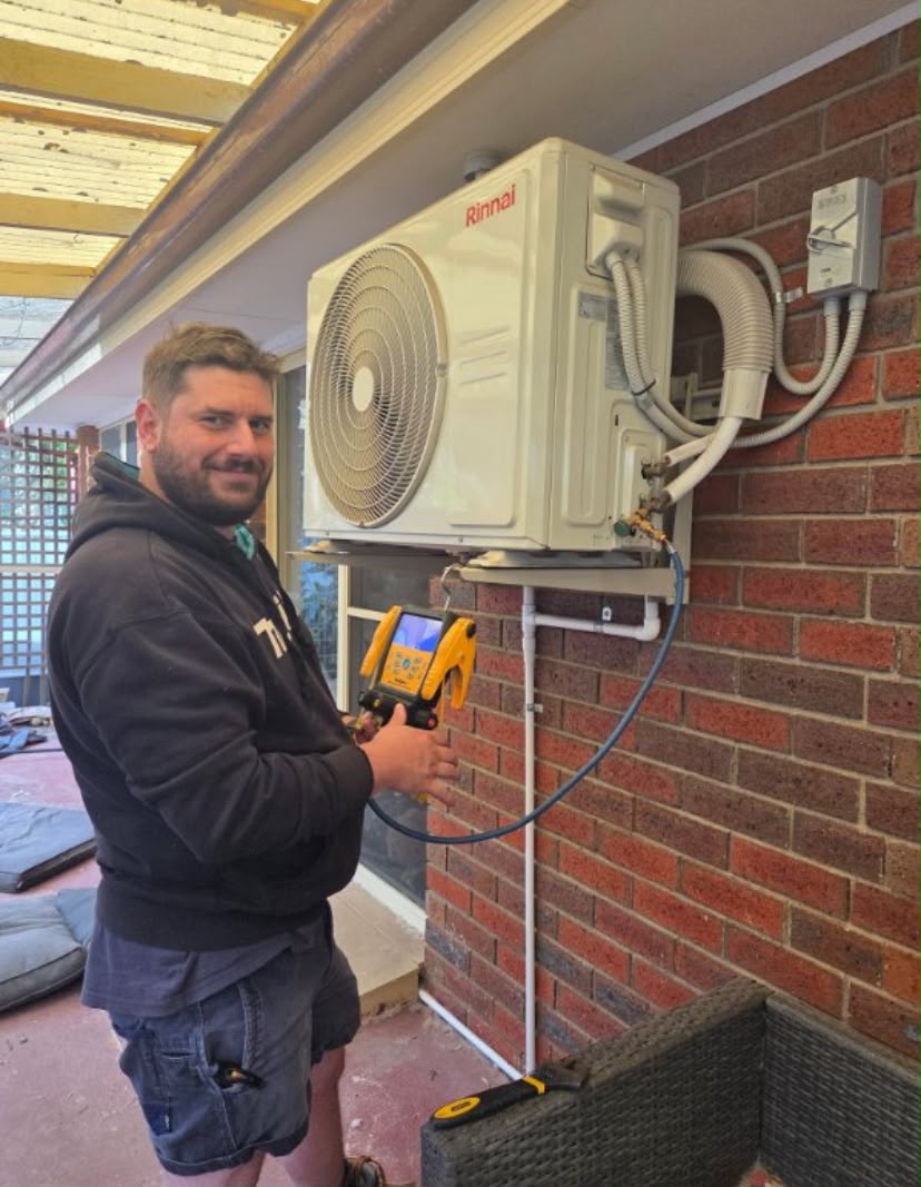 DK Mech technician installing an air conditioning unit
