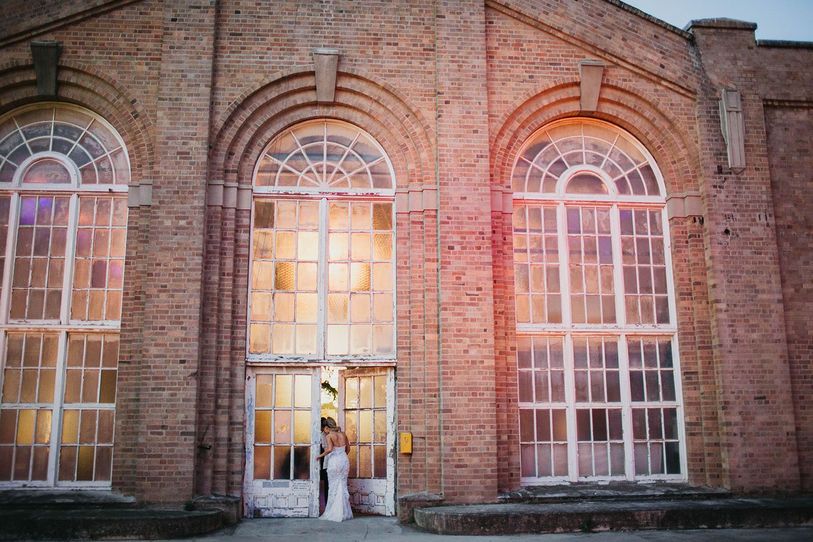 A couple at the arched doors of the old brick Powerhouse