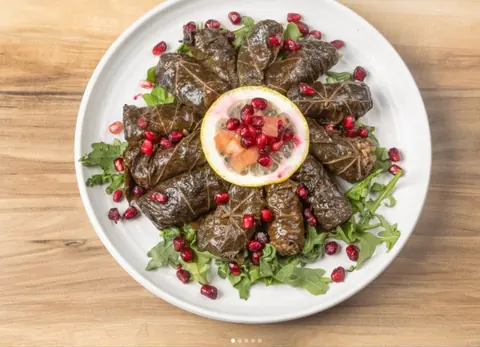 Stuffed vine leaves with pomegranate and lemon on rocket