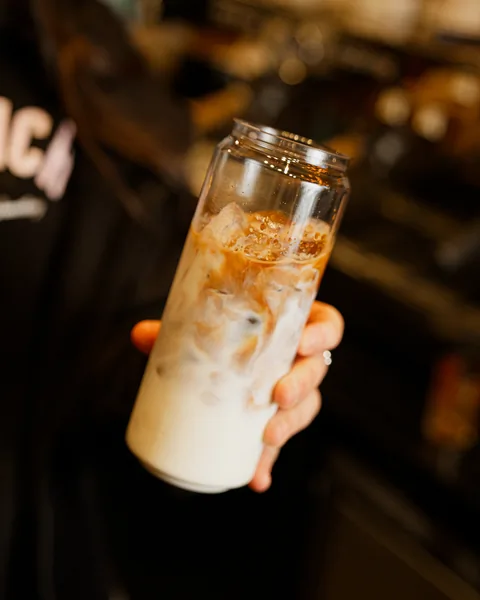 Iced latte held up at the counter