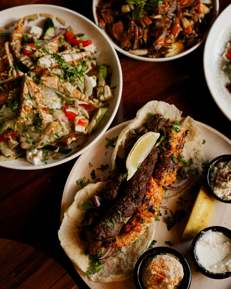 Overhead view of chicken salad, kafta and dips to share