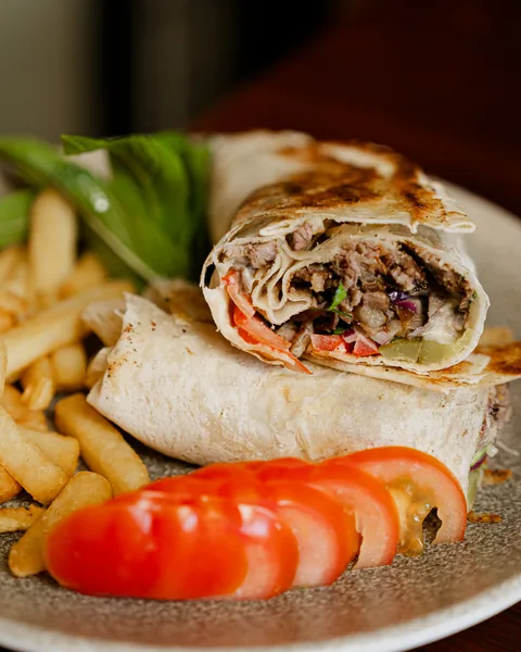 Shawarma wraps cut in half with chips and tomato