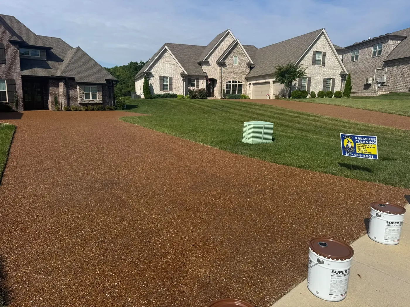 Newly sealed driveway in front of a brick home