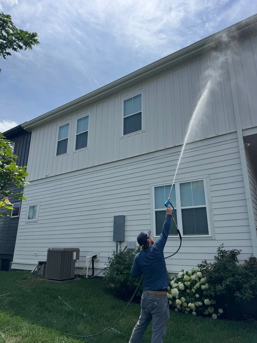 Wash Wizard technician soft washing two-story siding in Hendersonville, TN