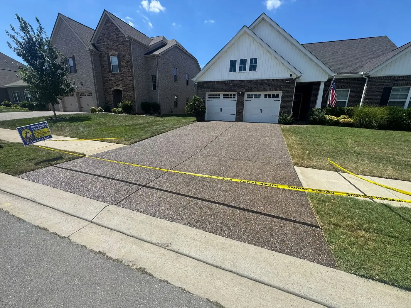 Freshly sealed aggregate driveway with caution tape in a Sumner County neighborhood