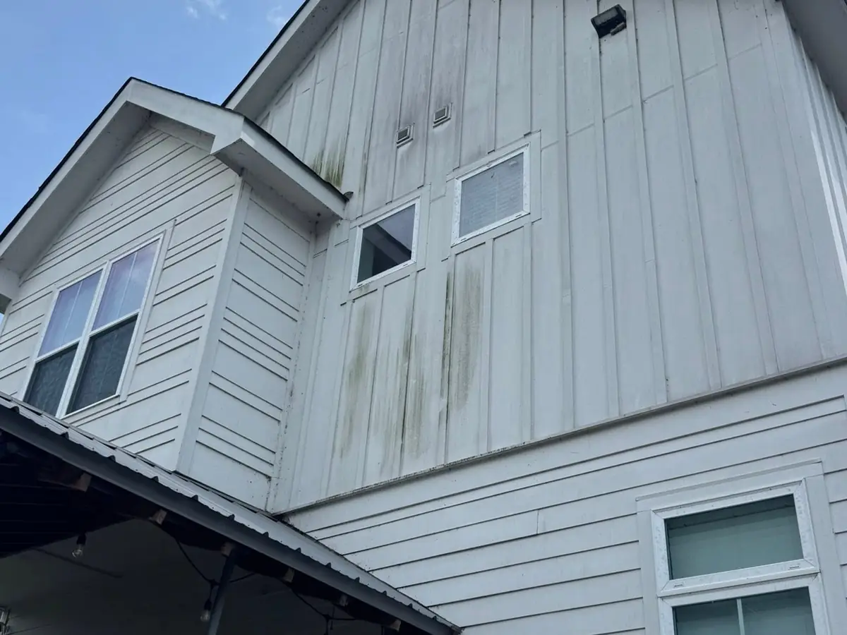 Before: black streaks on two-story board and batten siding