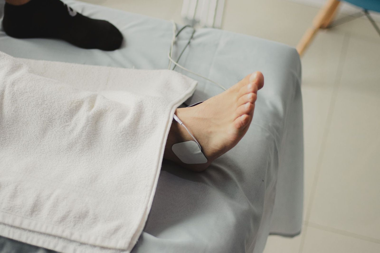 A bare foot with an electrotherapy pad