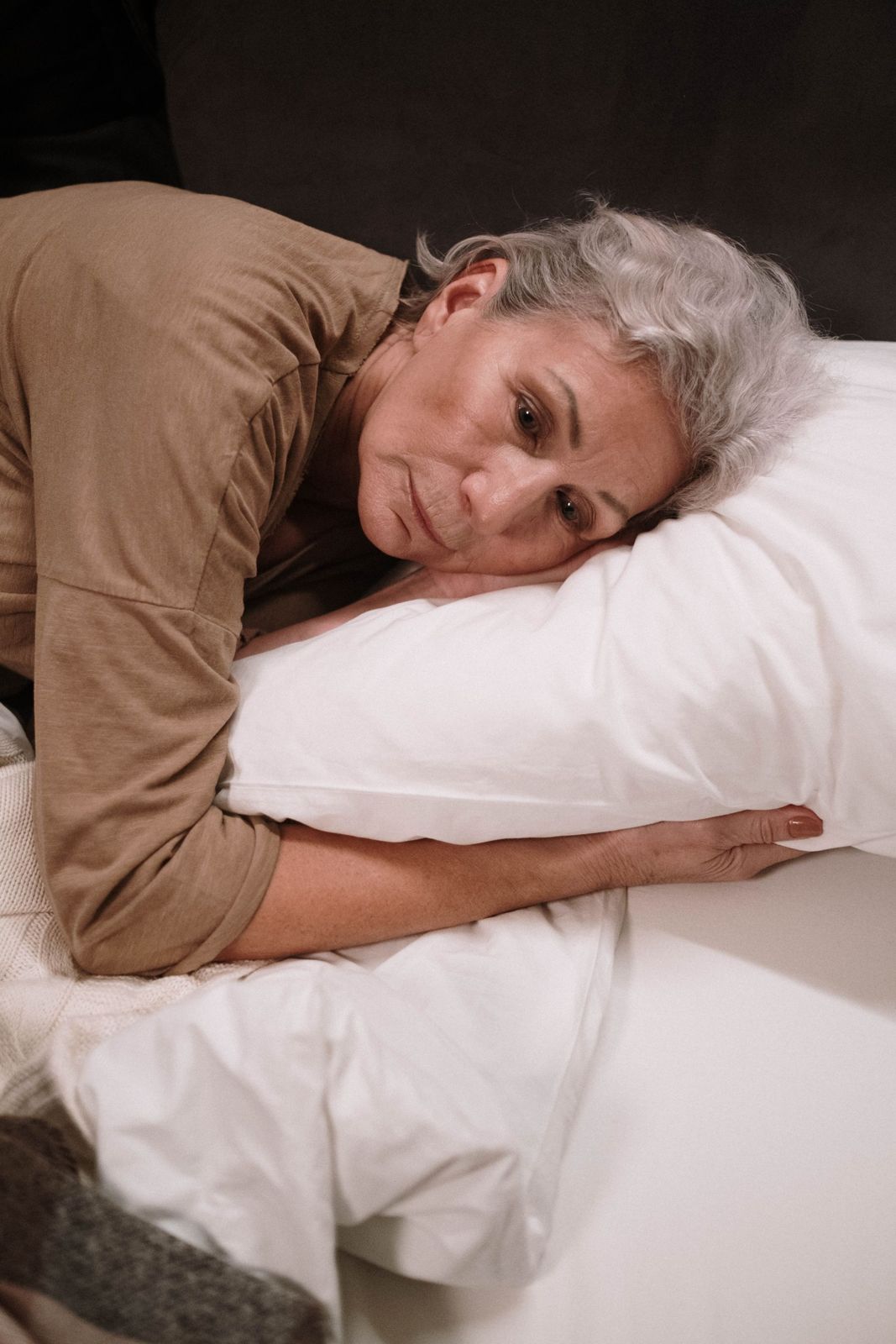 An older woman lying awake in bed