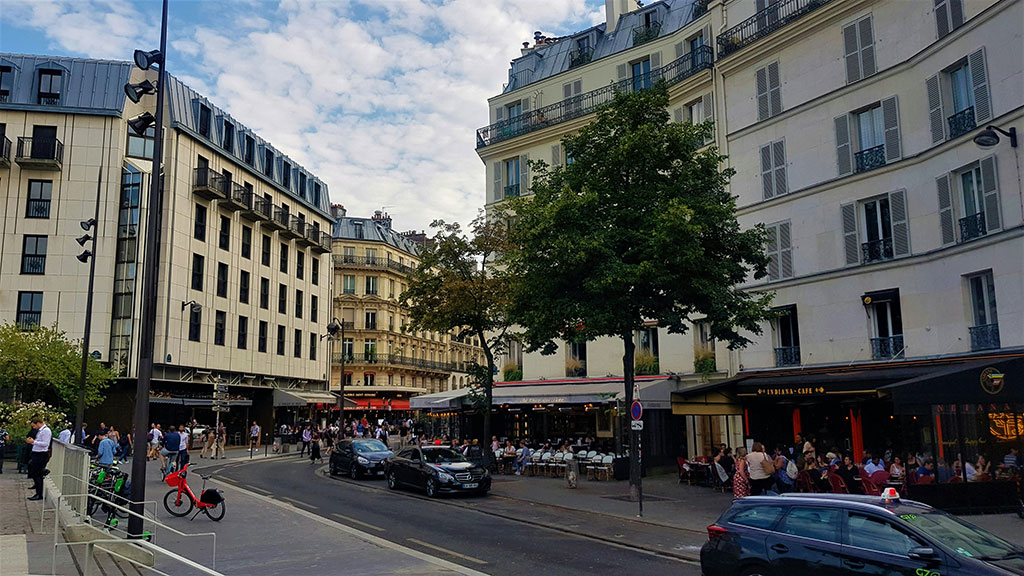 photo d'une rue animée de Paris, composées de commerces et de copropriétés, spécialitée du Cabinet Kerboull 