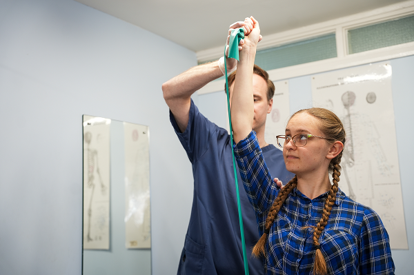 A physiotherapist carrying out a shoulder assessment