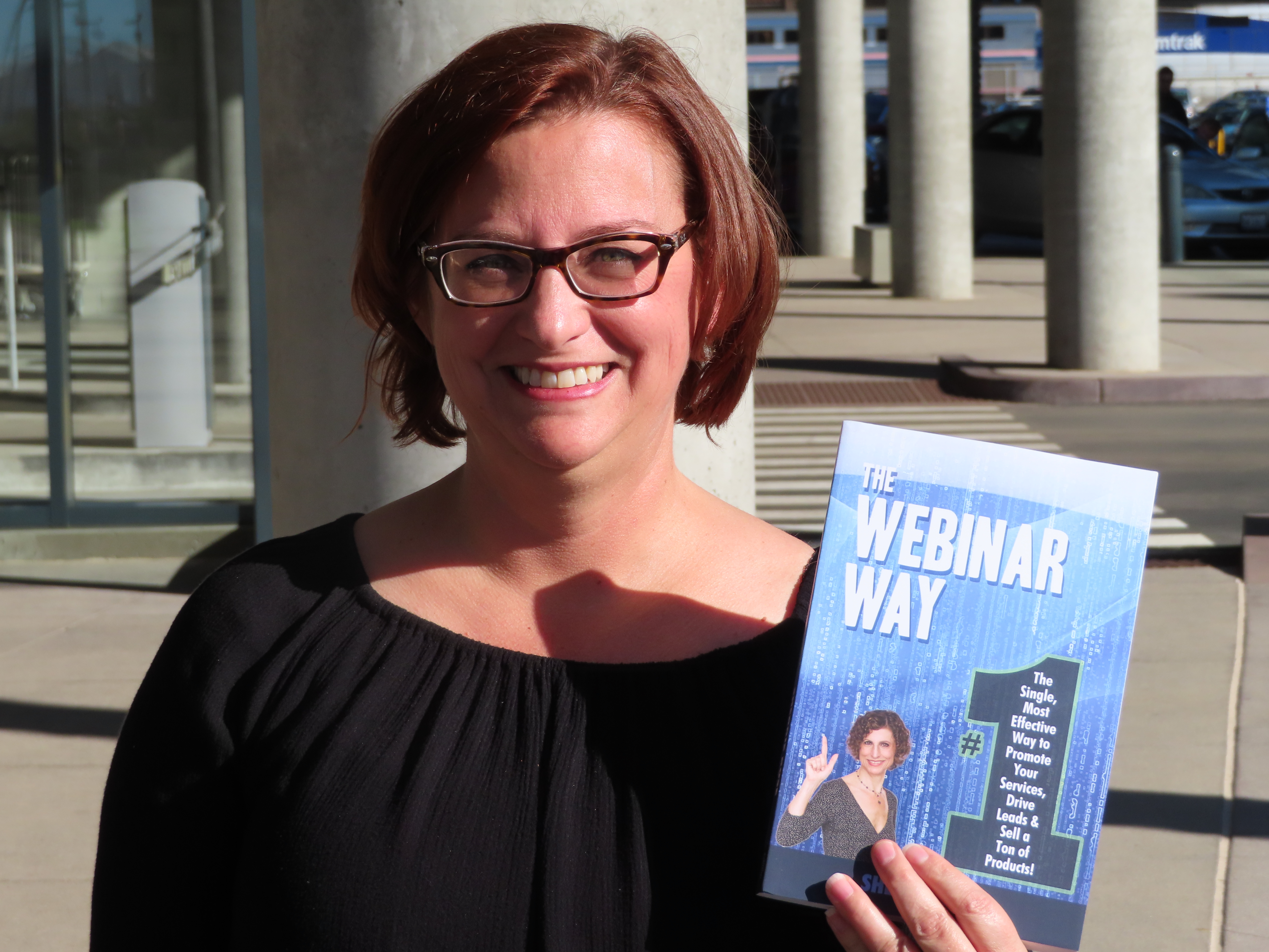 A reader holding The Webinar Way